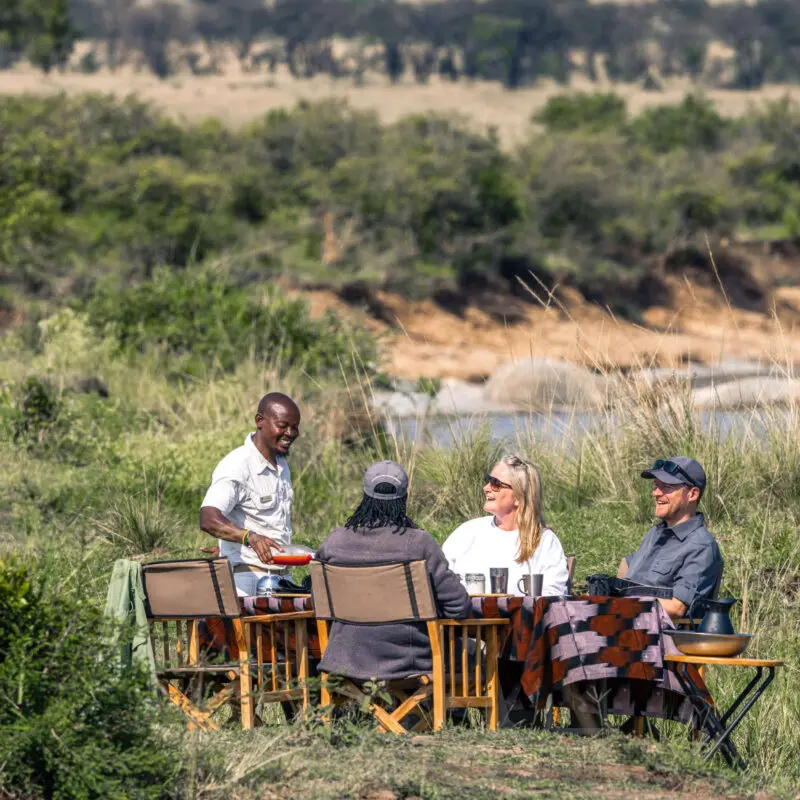 Guests being served lunch on the banks of the river in Serengeti National Park