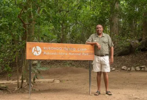 David standing next to the Rubondo Island Camp sign, Rubondo Island National Park, Tanzania.