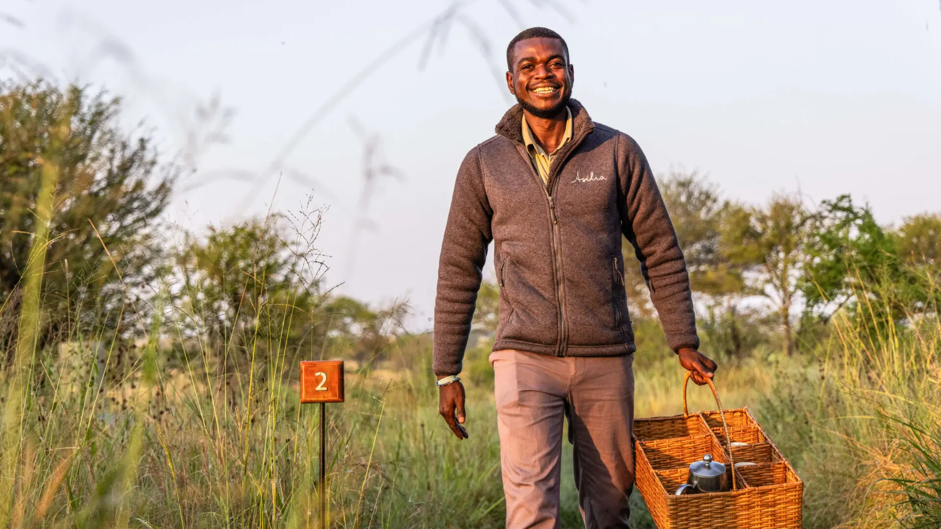 Smiling staff member on his way to guest tent at Olakira
