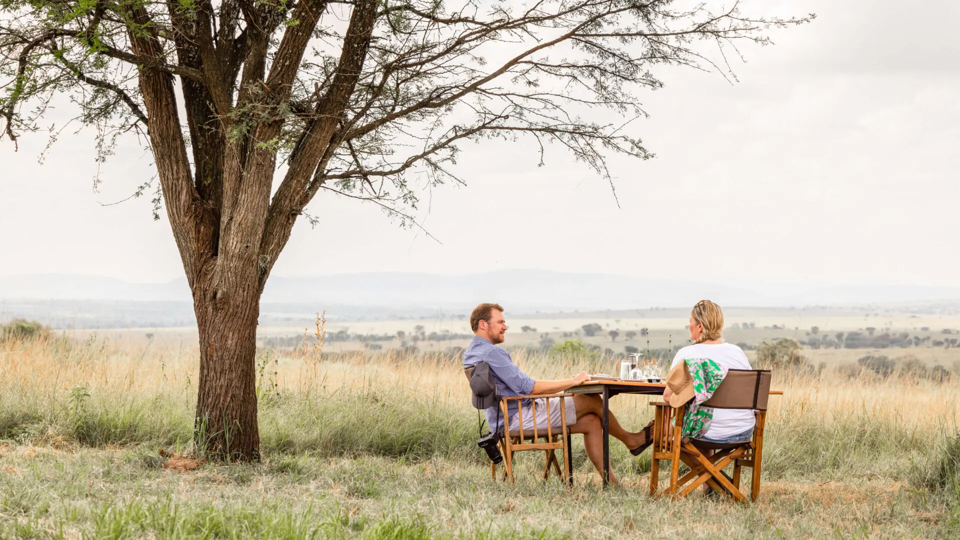 couple enjoying a meal in the bush near a tree in the Serengeti