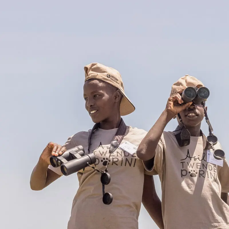 Two children with binoculars on an Asilia Africa Twende Porini trip at Rekero Camp in Tanzania