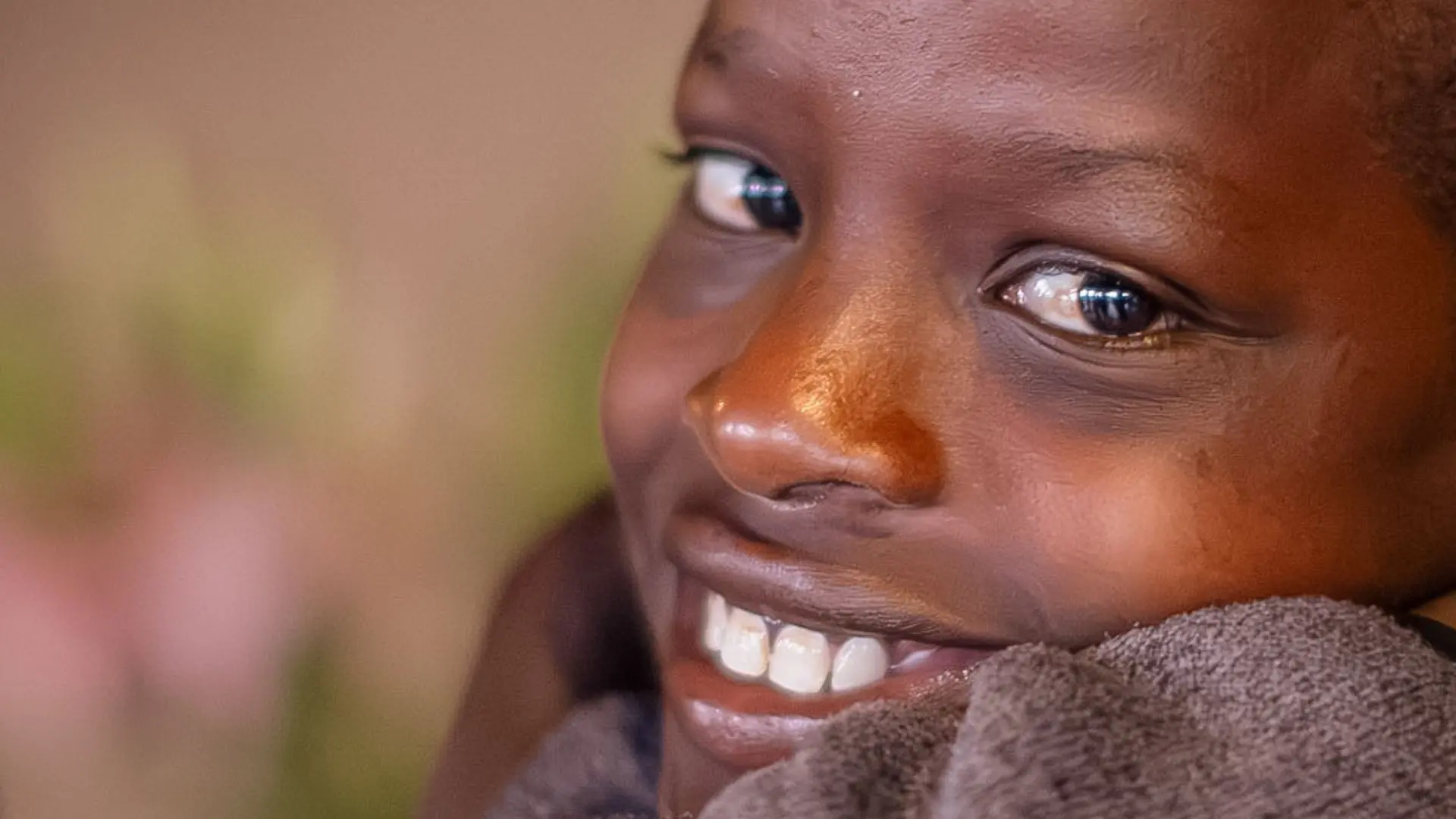 close up of a smiling child at an Asilia Africa Twende Porini trip at Rekero Camp in Tanzania