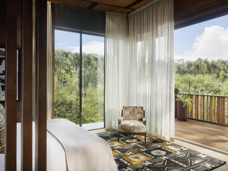 One Only Gorilla's Nest Guest suite interior with balcony and view of the forest, double bed