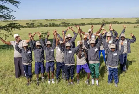 Happy children enjoying Asilia's Twende Porini program in the Masai Mara, Kenya.