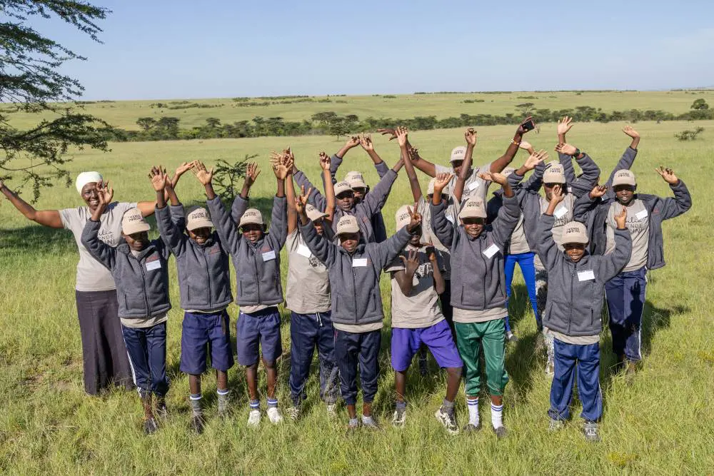 Happy children enjoying Asilia's Twende Porini program in the Masai Mara, Kenya.