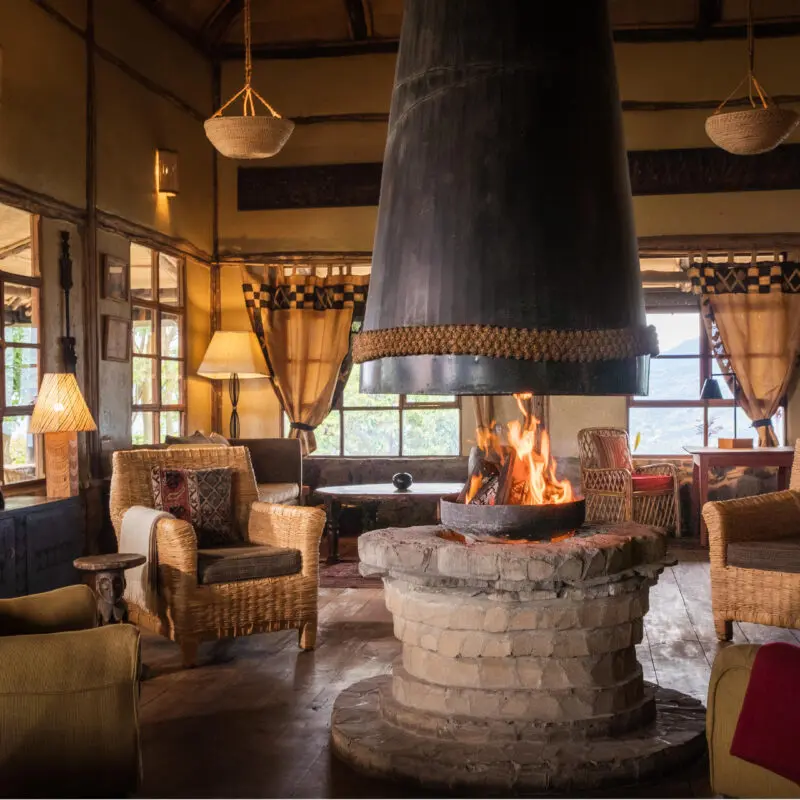 Volcanoes Virunga Lodge indoor lounge area with firepit in the centre and seating