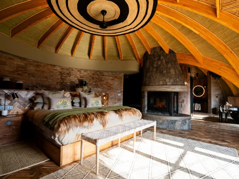 Wilderness Bisate Guest bedroom interior with fireplace and double bed