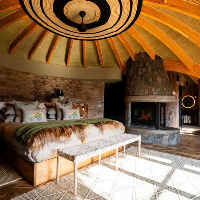 Wilderness Bisate Guest bedroom interior with fireplace and double bed