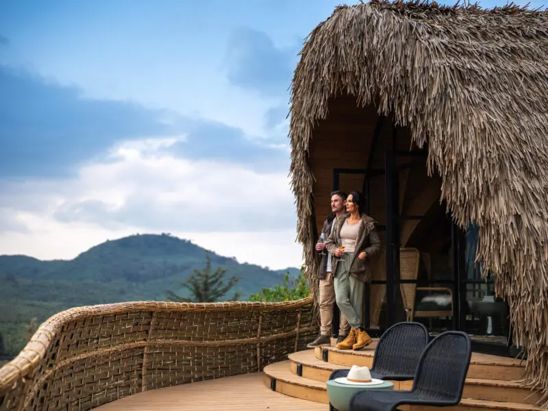 Wilderness Bisate guests standing on the balcony of their room enjoying the view