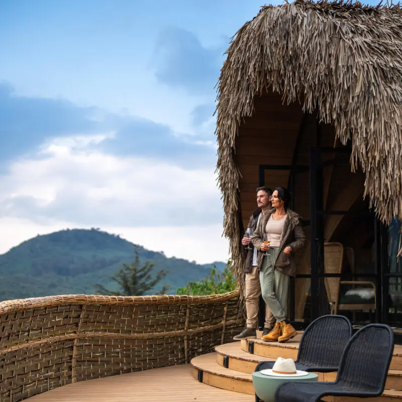 Wilderness Bisate guests standing on the balcony of their room enjoying the view