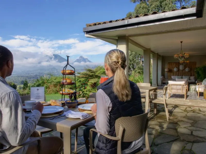 Wilderness Sabyinyo Guests enjoying breakfast outside with a view