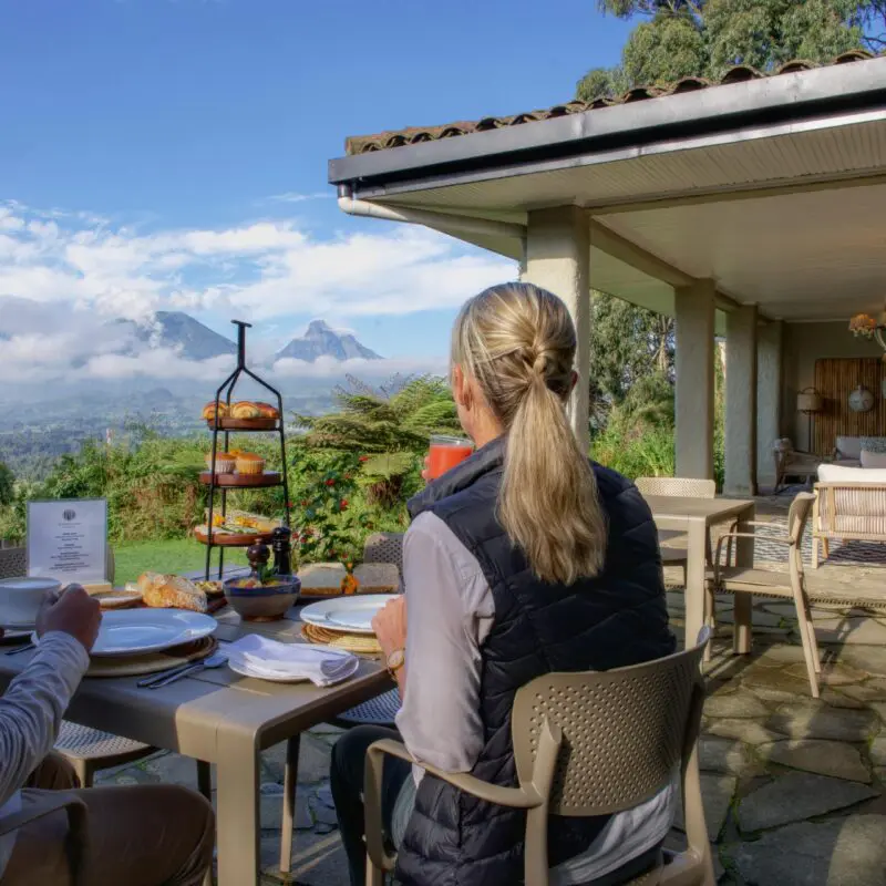 Wilderness Sabyinyo Guests enjoying breakfast outside with a view