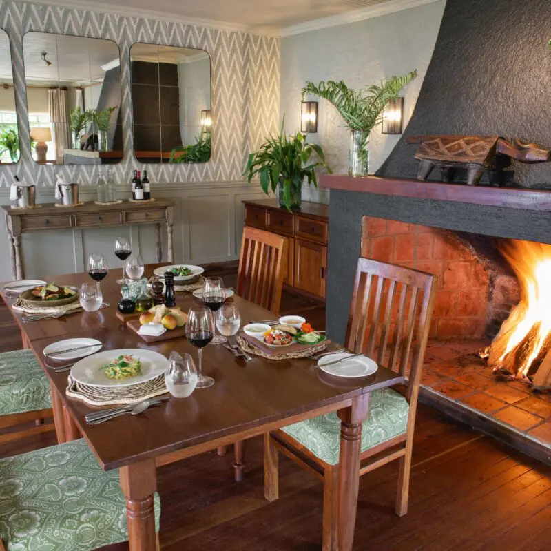 Wilderness Sabyinyo dining setup near the fireplace