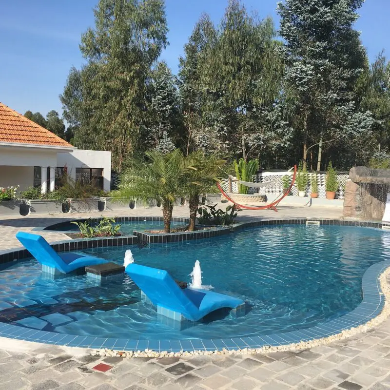 Five Volcanoes outdoor pool with loungers and rock formation waterfall