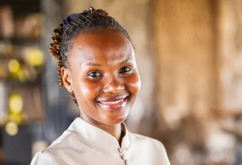 headshot of smiling waitress at namiri plains safari camp, tanzania, asilia africa