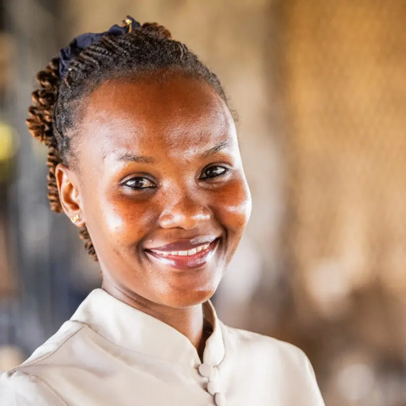 headshot of smiling waitress at namiri plains safari camp, tanzania, asilia africa