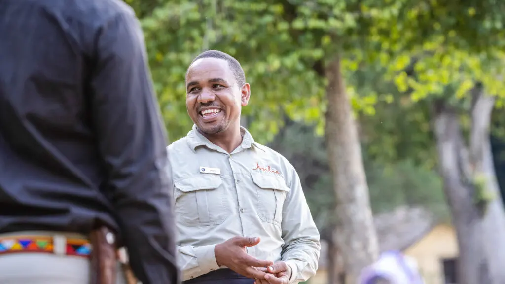 male staff member laughing with a guest on safari - asilia africa