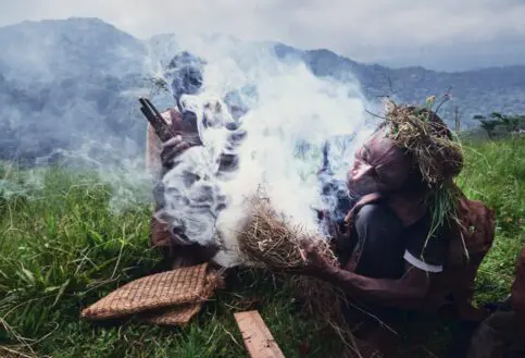 Preparing smoke ahead of the collection of honey, Bwindi, Uganda.
