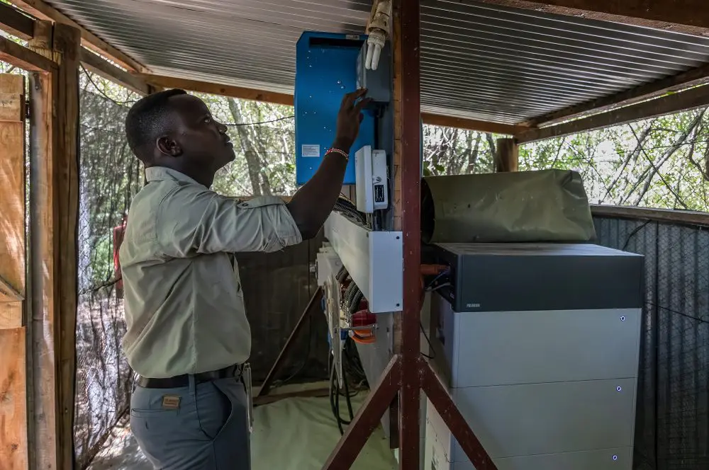 A staff member monitors the solar system in camp, Kenya.