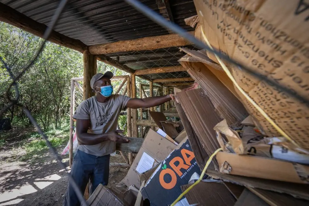 A staff member sorts recycling waste in camp.