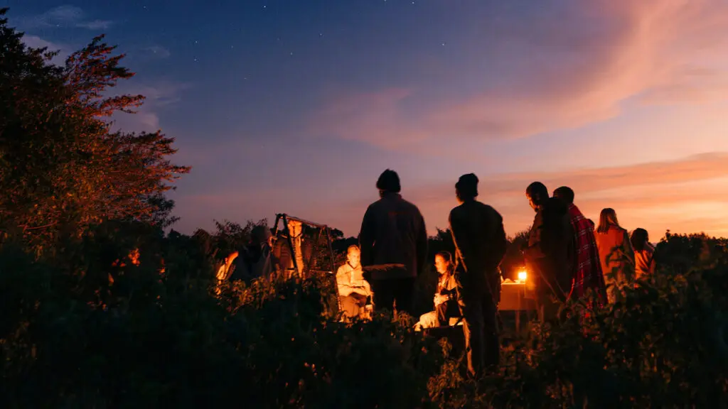 a group of emboo guests together at the camp fire at emboo in the maasai mara