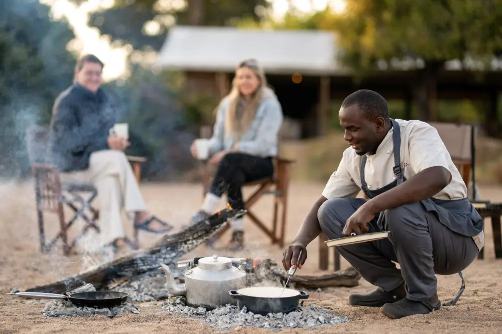 Chef preparing breakfast over the open fire in Kokoko Camp, Ruaha National Park.