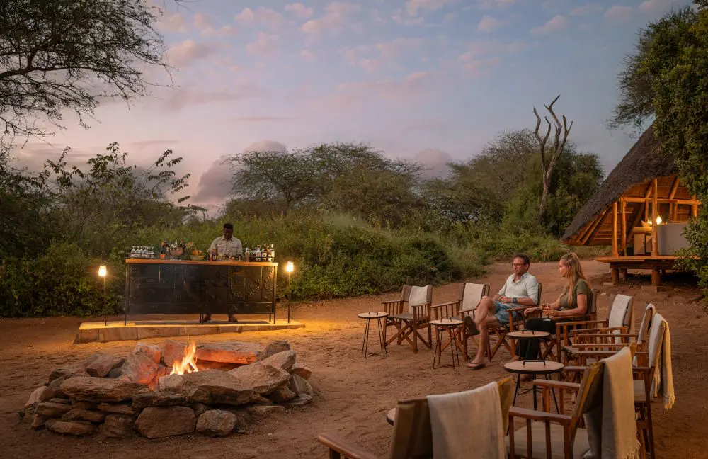 Guests enjoying fireside sundowners in Oliver's Camp, Tarangire National Park, Tanzania.