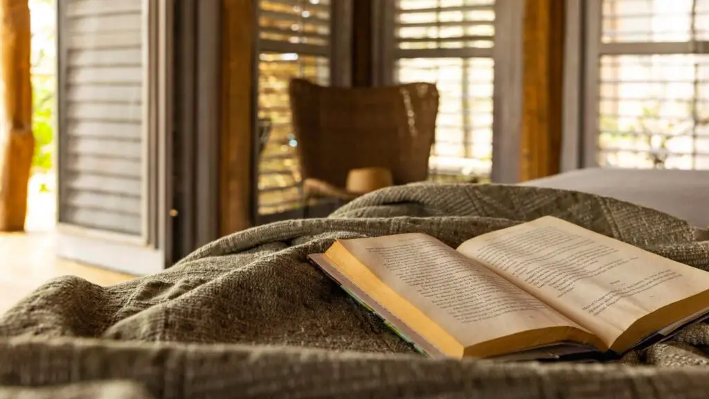 A book rests open on a bed in a luxury safari suite