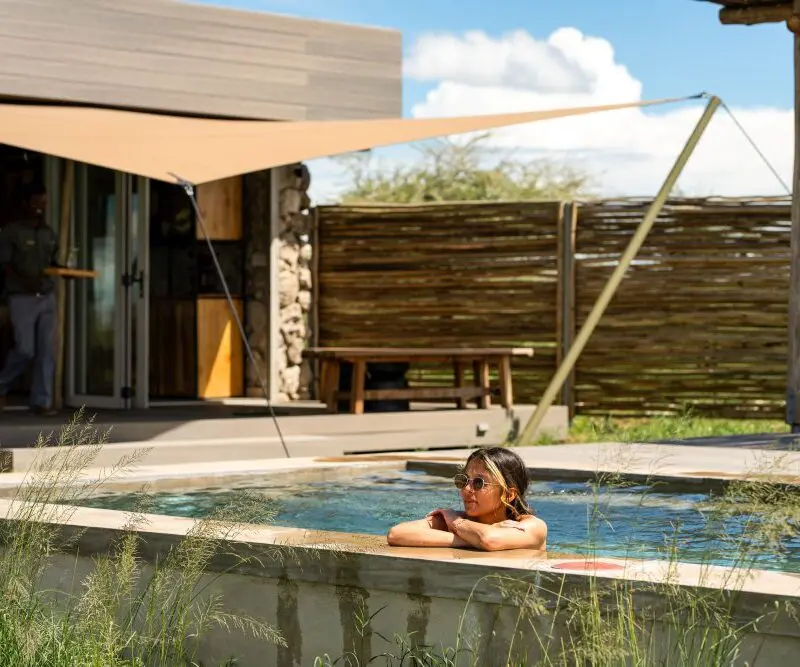 A guest enjoys the swimming pool at Namiri Reterats, Serengeti National Park, Tanzania.