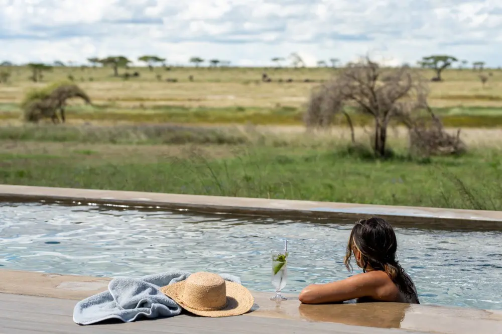 A guest enjoys the swimming pool, Namiri Plains, Serengeti National Park, Tanzania.