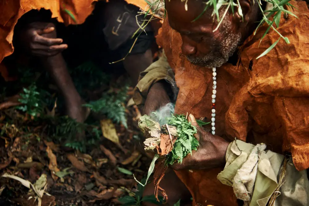 A Batwa member creates fire, Bwindi, Uganda.