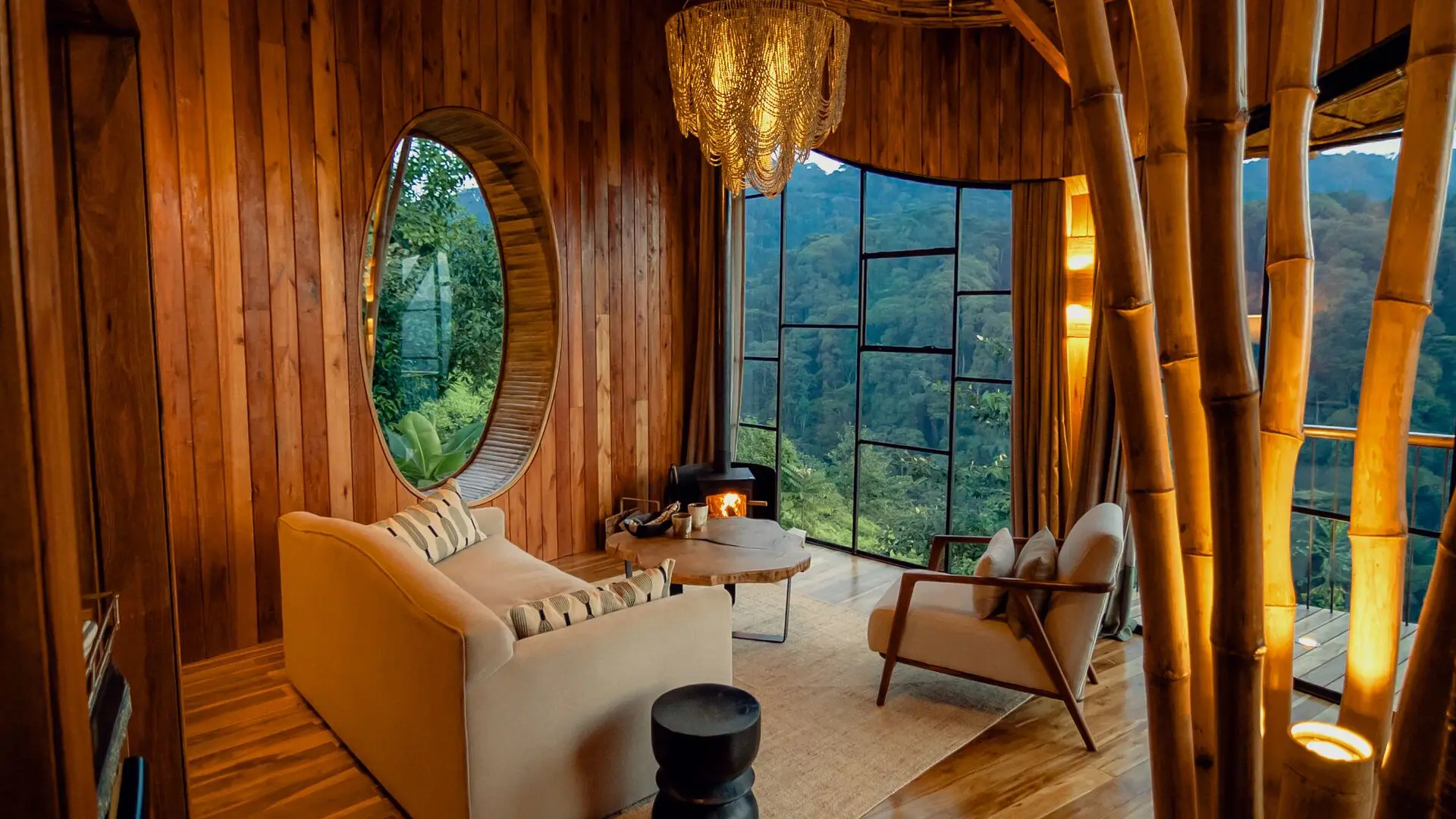 Timber lounge at Erebero Hills with a fireplace, comfortable seating and large windows overlooking the forest.
