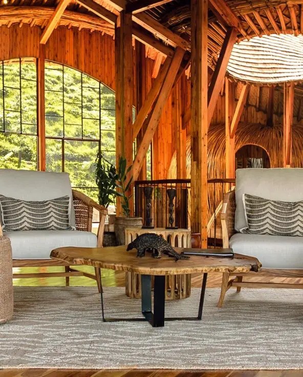 Two cushioned armchairs and a low wooden table in the timber-built lounge at Erebero Hills