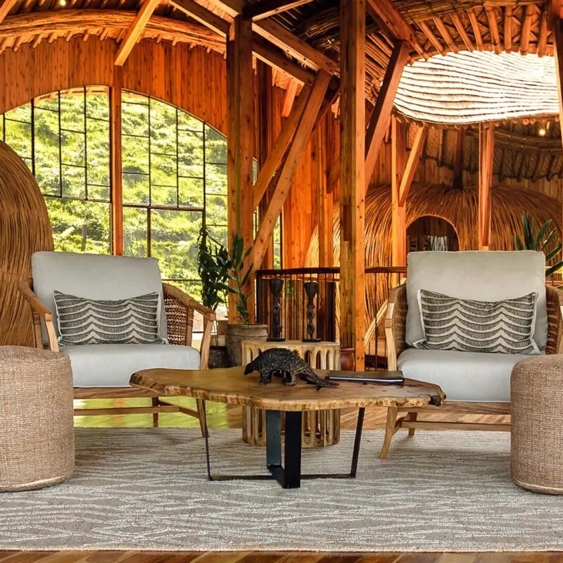 Two cushioned armchairs and a low wooden table in the timber-built lounge at Erebero Hills