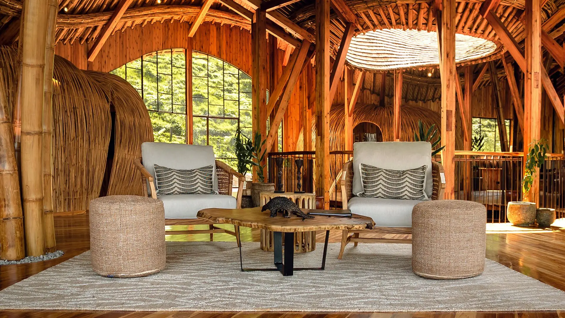 Two cushioned armchairs and a low wooden table in the timber-built lounge at Erebero Hills