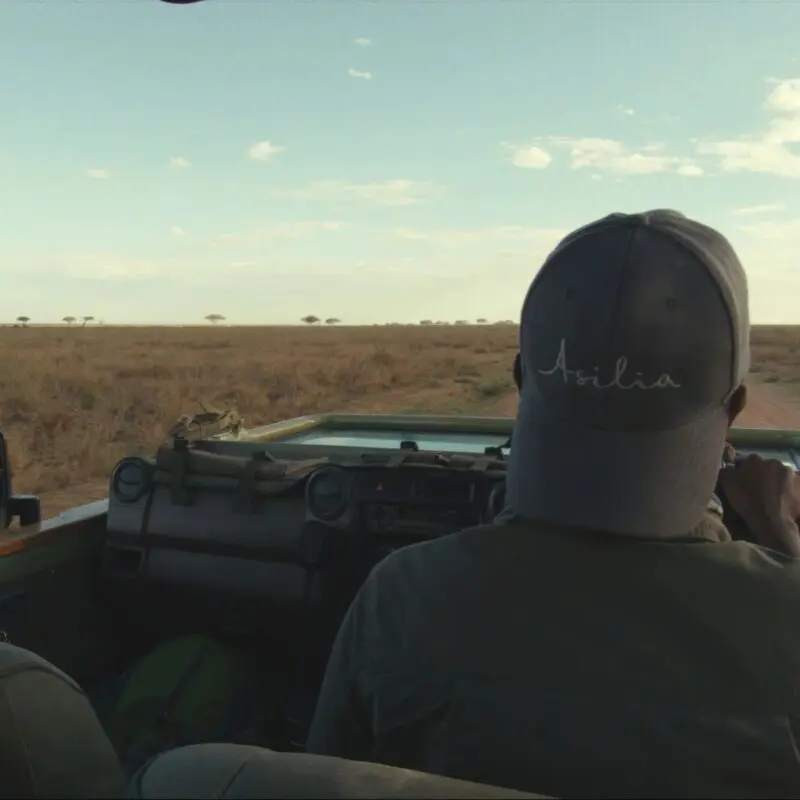 Asilia guide driving down the dusty road of the Serengeti National Park.