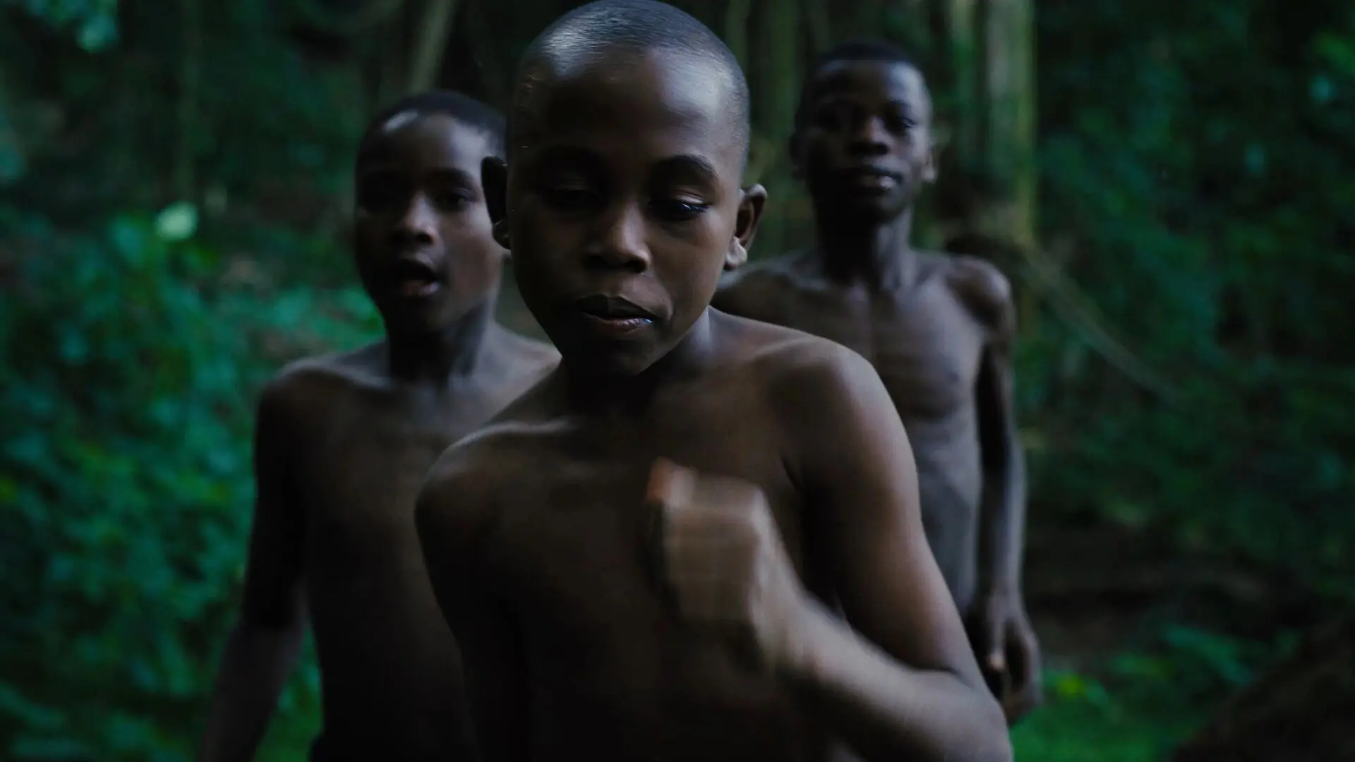 Young boys dancing while on a walk of the Rubondo Island Forest.