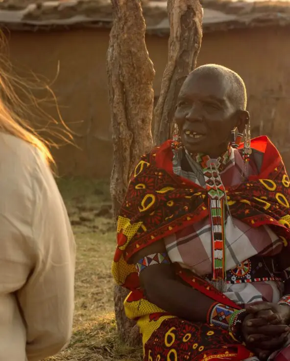 Asilia guest and Maasai elder sharing conversation at their village in The Highlands.
