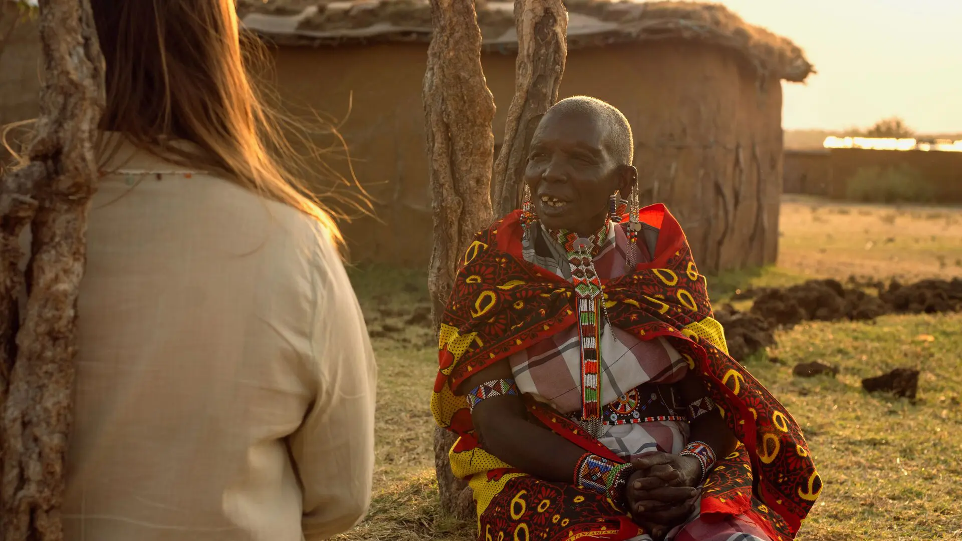 Asilia guest and Maasai elder sharing conversation at their village in The Highlands.