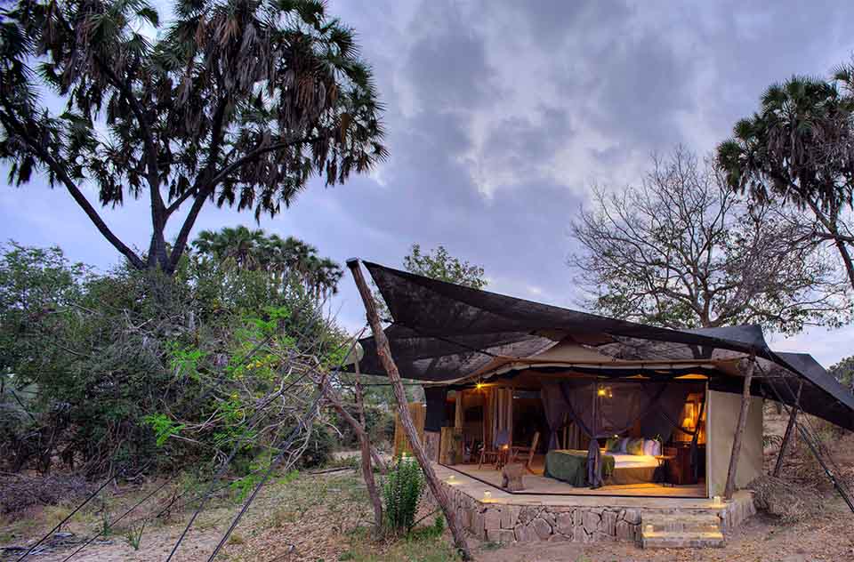 A guest tent at Roho ya Selous, positioned amongst the vegetation close to the water’s edge.