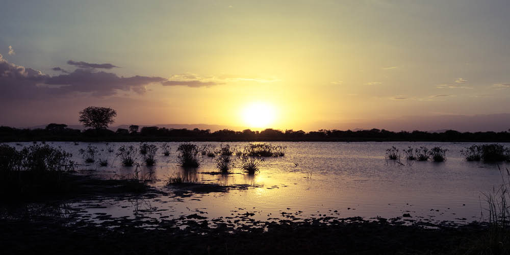 sun in a cloudy sunset over the lake