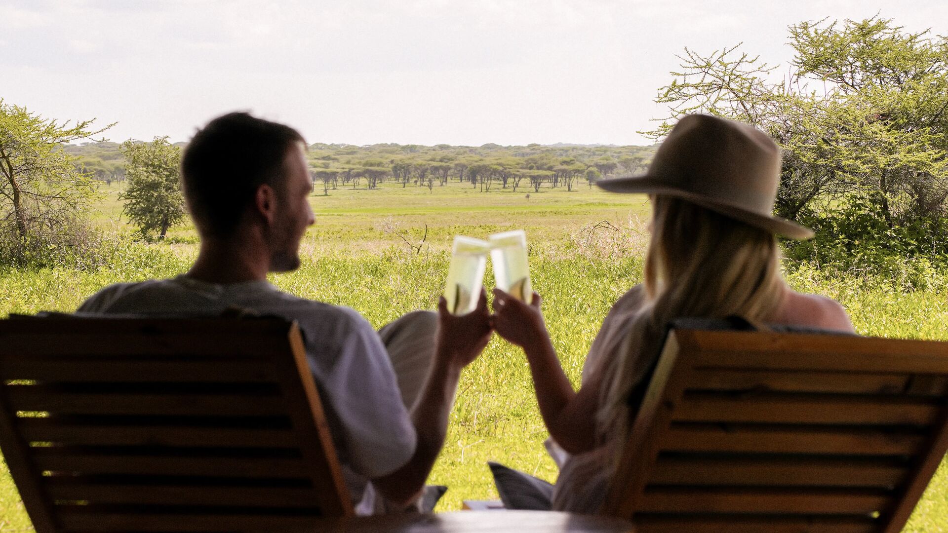 a couple enjoying a drink overlooking the grasslands of Ruaha National Park