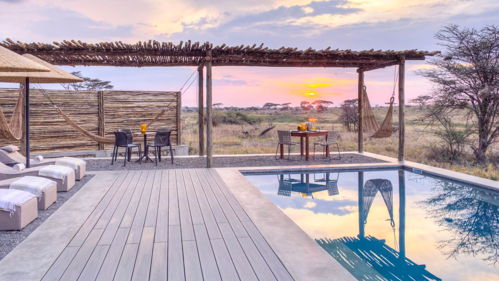 Namiri Plains, Serengeti National Park, pool at sunset, loungers on the deck, table and chairs, hammock