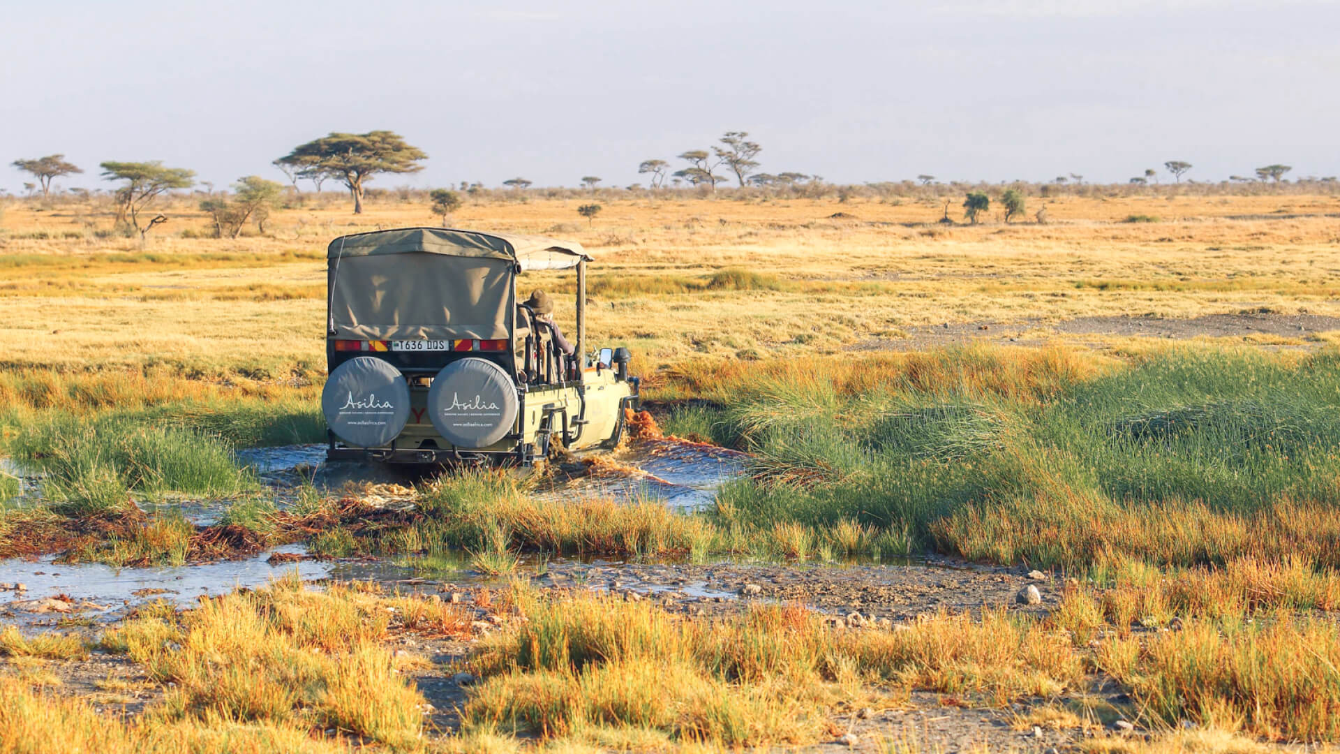 Namiri Plains Retreat, Serengeti National Park, guests on game drive through wet terrain