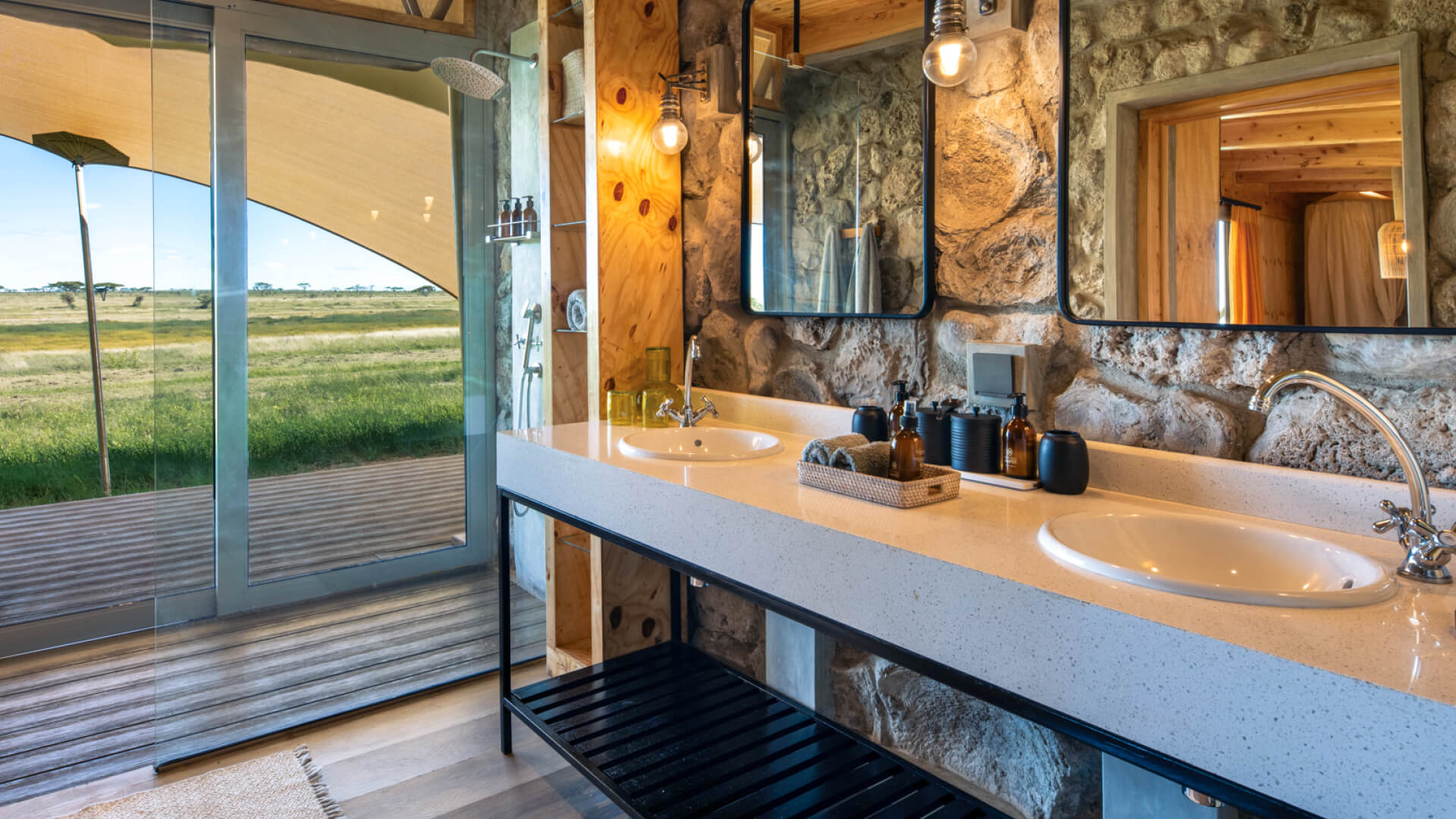 Namiri Plains Retreat, Serengeti National Park, guest bathroom, shower with glass doors and double vanity with amnenities, mirrors and lights above