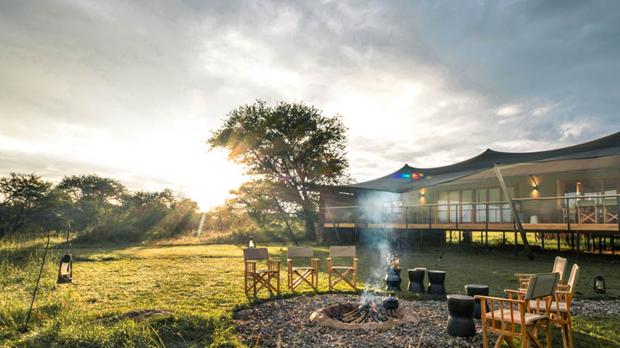 Sayari Retreat, Serengeti National Park, firepit surrounded by chairs for breakfast preparation in front of the retreat