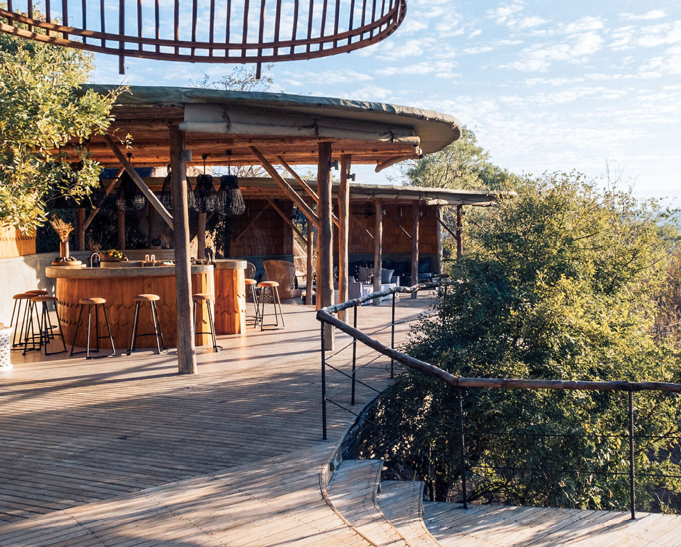 Jabali Ridge, Ruaha National Park, bar with stools and lights leading to seated area in the daytime