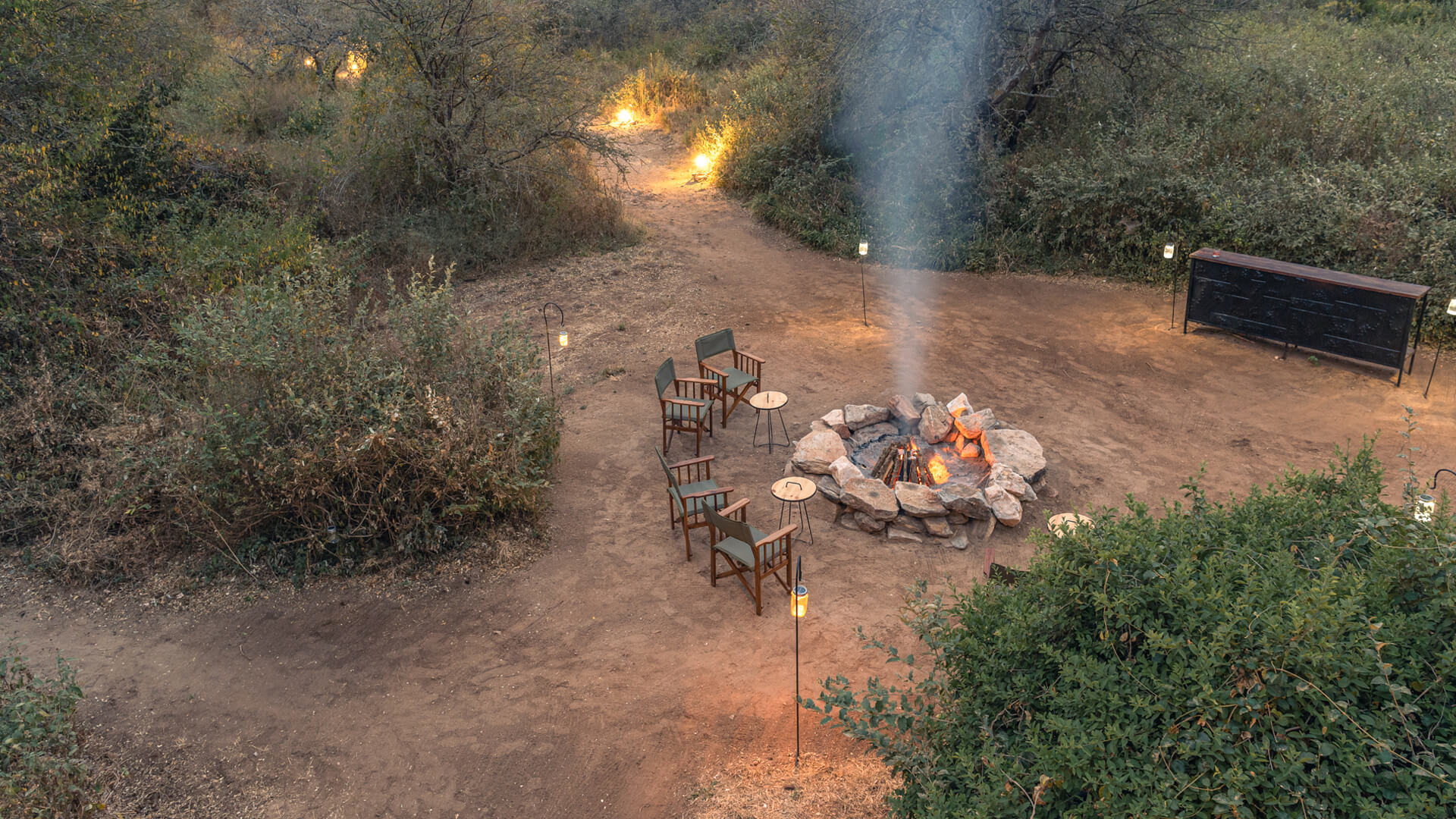 A campfire encircled with chairs where guests can catch up at the end of a day in Tarangire