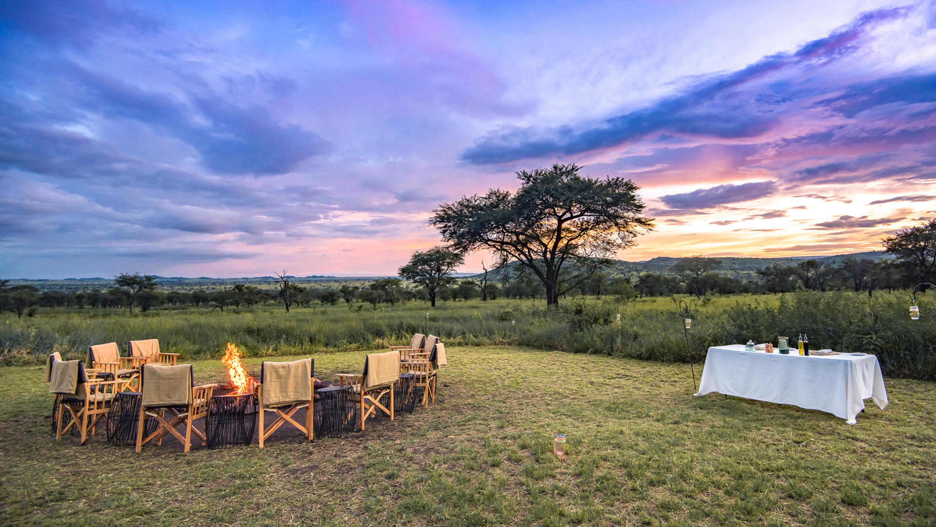 Fireside sundowners at Dunia Camp with views across the Serengeti plains, Tanzania