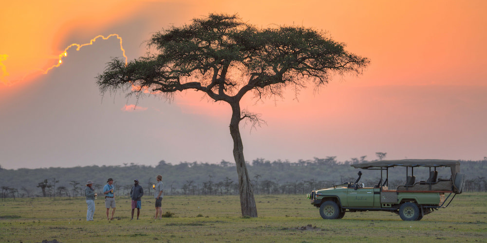 Guests enjoying sundowners after a game drive in Mara Naboisho Conservancy